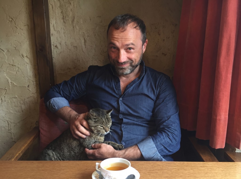 Wolfgang Eißler mit Katze an einem Holztisch